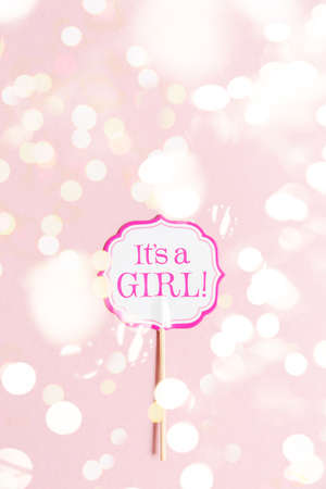 Its a girl sign at the baby shower party. Pink solid background. Baby shower celebration concept. Minimalistic party background. Vertical Top view with festive holiday bokehの写真素材