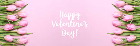 Happy Valentines Day wording with pink tulips on the pink background. Flat lay, top view. Valentines background. Horizontal, banner formatの写真素材