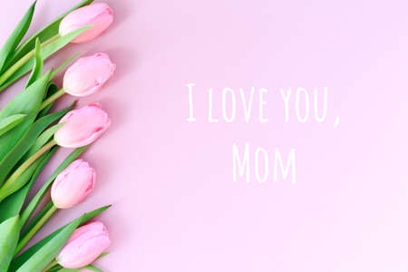 I love you, Mom wording with pink tulips on the pink background. Flat lay, top view. Mothers day holiday celebration card. Horizontal,の写真素材