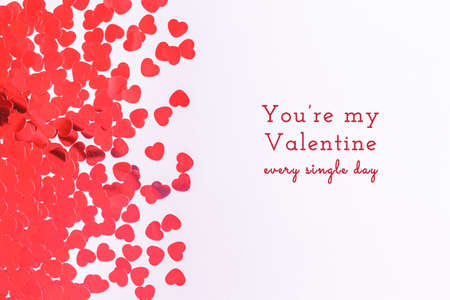 Glitter heart confetti border on light grey. Valentine day concept. Trendy minimalistic flat lay design background. Horizontal with holiday Valentines textの写真素材