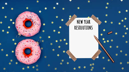 Holiday season card with New Year Resolutions and Christmas tree toy donuts on classic blue, place for text, banner formatの写真素材