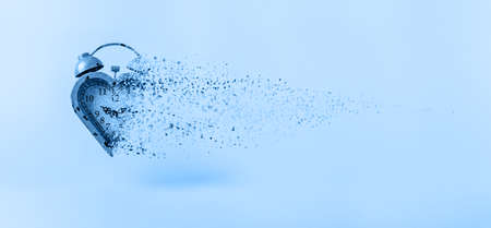 Heart shaped clock dispersing toned in classic blue. Valentines day and love infitity and duration concept, romance ending. Horizontal, banner wide screen formatの写真素材