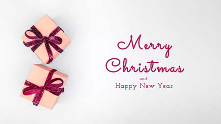 Craft boxes with dark red ribbon bows. Holiday, Christmas, New Year and Valentine day eco-friendly wrapping concept. Trendy minimalistic flat lay design. Wide screen banner with Seasonal greetingsの写真素材