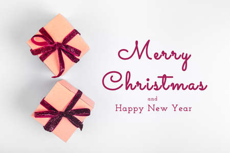 Craft boxes with dark red ribbon bows. Holiday, Christmas, New Year and Valentine day eco-friendly wrapping concept. Trendy minimalistic flat lay design background. Horizontal with Seasonal greetingsの写真素材