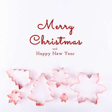 Flatlay with holiday tree and snowflake copper cookie cutters on white sparkling background. Holiday, Christmas and New Year concept. Flat lay, top view background. Horizontal with Seasonal greetingsの写真素材