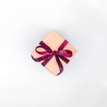 Craft boxes with dark red ribbon bows. Holiday, Christmas, New Year and Valentine day eco-friendly wrapping concept. Trendy minimalistic flat lay design background. Squareの写真素材