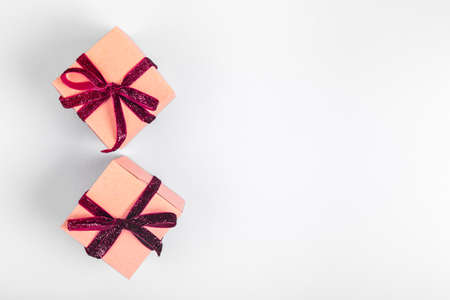 Craft boxes with dark red ribbon bows. Holiday, Christmas, New Year and Valentine day eco-friendly wrapping concept. Trendy minimalistic flat lay design background. Horizontalの写真素材