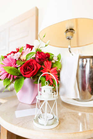Lighthouse candle holder with champagne bottle and flower basket in the upscale hotel room. Being alone, getaway, staycation, digital detox, summer vacation concepts. Verticalの写真素材