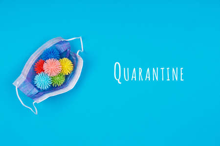 Medicine mask with plastic balls viruses on the blue background with Quarantine wording. Epidemic,...