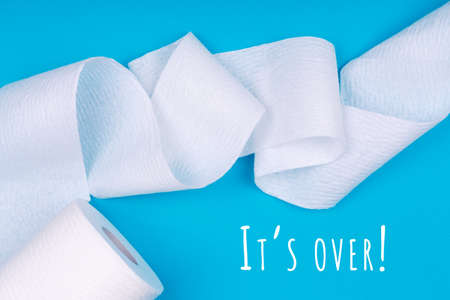 Toilet paper roll on the bright blue background with Its over wording. Coronavirus pandemic panic shopping concept. Bright monochrome dropの写真素材