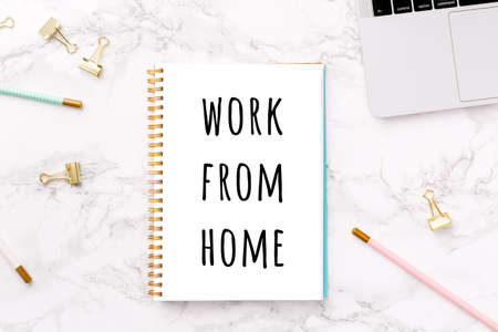 Festive golden stationary on white marble background with Work from home wording. Feminine job, home office, distancing, social isolation, work from home and career concept. Top view. Horizontalの写真素材