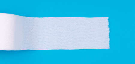 Toilet paper roll on the bright blue background. Coronavirus COVID-19 pandemic panic shopping, social distancing concept. Bright monochrome drop in wide screen banner format with place for textの写真素材