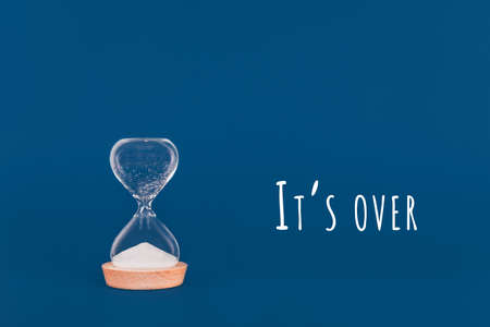 Hourglass with the finished sand with Its over wording. Concept of time and timely actions. Classic blue dropの写真素材