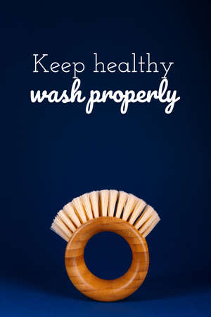 Modern futuristic round bamboo brush for fruits and vegetables on classic blue background with Keep healthy wash properly wording. Safe cleaning and organic produce concept. Copyspaceの写真素材