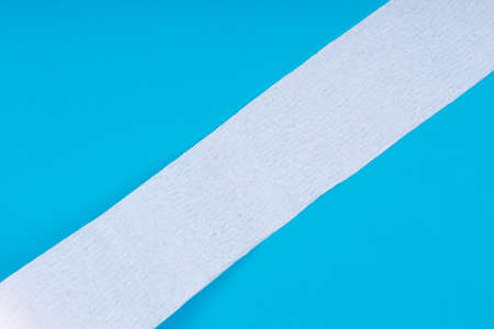 Toilet paper roll on the bright blue background. Coronavirus COVID-19 pandemic panic shopping, social distancing concept. Bright monochrome drop with diagonal line and place for textの写真素材