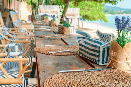 Empty tables ready for guests at the beach restaurant and bar near the sea. Vacation, get away, summer outing, crisis, lockdown conceptの写真素材