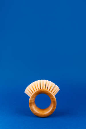 Modern futuristic round bamboo brush for fruits and vegetables on classic blue. Safe cleaning and organic produce concept. Copyspaceの写真素材