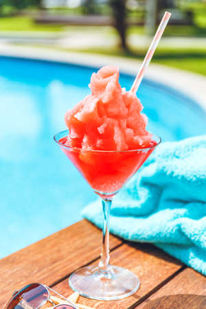 Frozen Margarita or Daiquiry cocktail near the pool. Vacation, summer, holiday, luxury resort concept. Coral shade drink. Verticalの写真素材