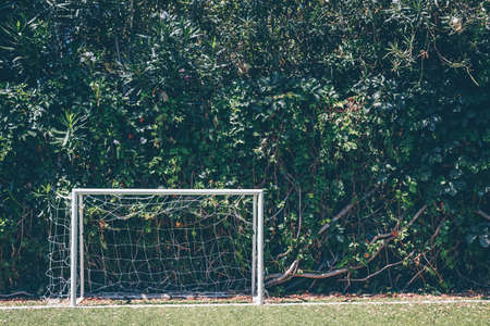 Soccer goal at the outdoor amateur field surrounded by green plant wall. Close to nature, healthy space, team game conceptの写真素材