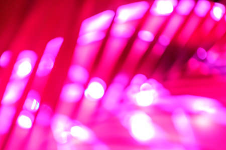 Futuristic blurred neon drop in red and pink with traces of palm greenery, place for text, easy cut to bannerの写真素材