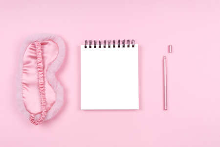 Note pad with cute flaffy sleeping mask and stylish pen. Beauty time, selfcare and sleep log, feminine time management and planning concept. Place for textの写真素材