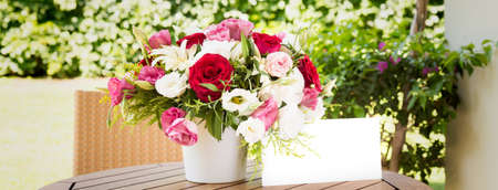 Bunch of flowers in reusable vase. Holiday, celebration, romance, online order and contactless delivery concept. Place for text on wide screen banner formatの写真素材