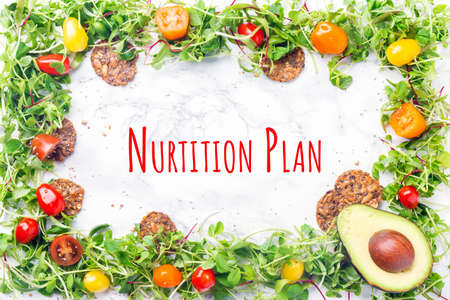 Microgreens frame with cherry tomatoes, seeds and nuts crackers and avocado with Nutrition Plan wording. Superfood snack concept. Horizontalの写真素材