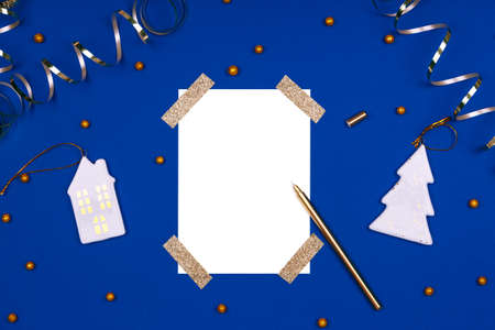 Isolated white card mock up with festive golden ribbons, confetti and Christmas toys. Flat lay...