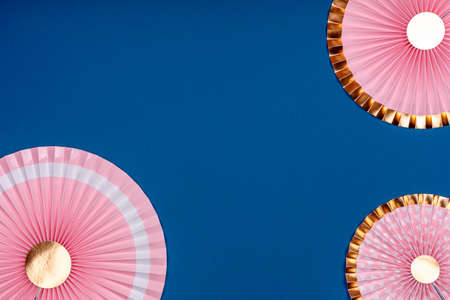 Pink and golden paper fans on classic blue drop. Party, decorations, celebration backdrop with place for textの写真素材