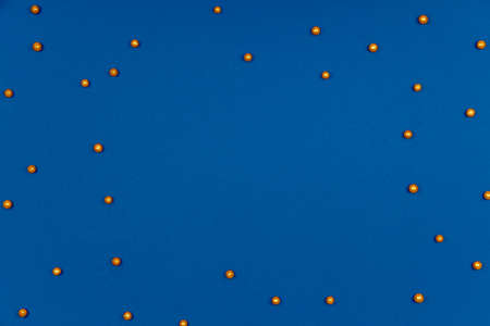 Pattern with golden Christmas or holiday round sprinkles on classic blue. Festive holiday drop with place for textの写真素材