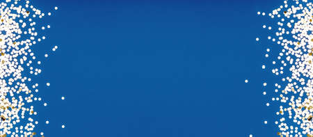 Festive small golden confetti on classic blue on two sides. Perfect background for any holiday project, place for text. Horizontal wide screen banner formatの写真素材