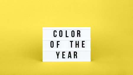 Retro lightbox with Color of the year wording on the trendy solid yellow backdrop in banner format, place for textの写真素材