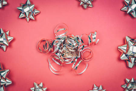 Gift box with recycled materials bow and silver gift bows on the red background with place for text. Traditional celebration and gift giving concept, eco friendly packagingの写真素材