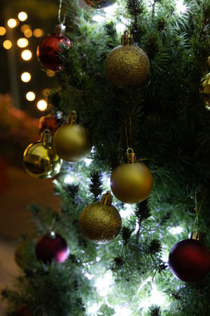 Close-up view on fir tree branch with Christmas balls and garlandの写真素材