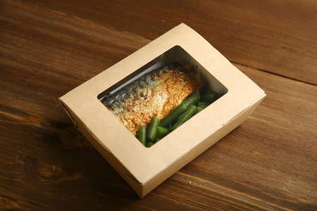 Delivery of food at home. Healthy and proper nutrition, grilled fish and green beans in a cardboard box. Low-calorie foodの写真素材