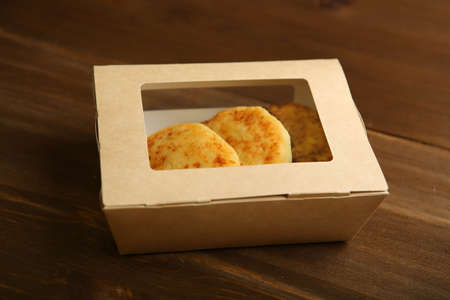 Delivery of products at home. Snack to takeaway. Cheese pancake made from cottage cheese in a disposable cardboard box. Correct, low-calorie foodの写真素材