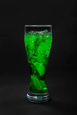 Summer green drink with lemon, lime and mint, ice on isolated black background. Direct perspective, cool, refreshingの写真素材