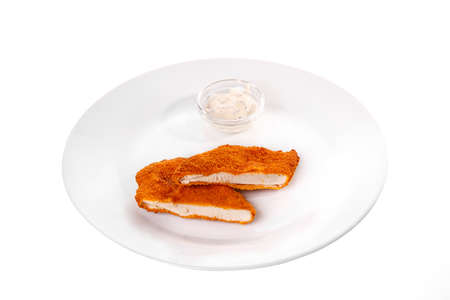 Schnitzel is cut into pieces of chicken, pork, meat, grilled, barbecue, on plate isolated white background. Tartar, sour cream, mayonnaise, white sauce. For the menu in the restaurant, bar. Side viewの写真素材