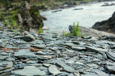 Rocky trail in mountainous terrain during the day for travelers, hiking in the fresh air, on the background of the river, in summer or spring, texture, free spaceの写真素材