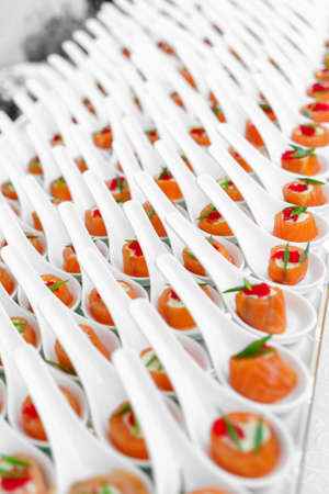 Celebration catering, small canapes of red fish - trout or salmon, in white portion bowls, side...