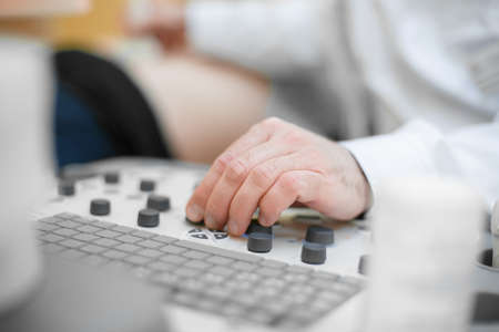 Doctor sets up an ultrasound machine, hand close up. Analysis, diagnosis of the condition of the disease using ultrasound scanningの写真素材