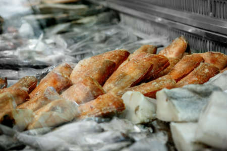 Close up of frozen seafood - red grouper, pollock, in the market of a fish shop, supermarket, horizontal frame, side viewの写真素材