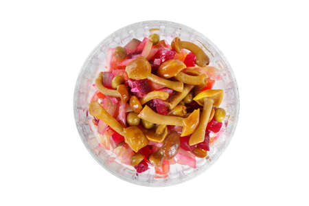 Salad of vegetables, of beetroot, the vinaigrette with beets, cucumber, peas, onions, cabbage, honey mushrooms on plate, white isolated background, view from above, for the menu, restaurant, bar, cafeの写真素材