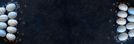 Easter banner background with polka dots and stripes blue eggs on dark textural background with...