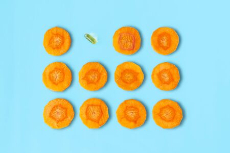 Sliced carrot pattern with capsule on pastel blue background. Fish oil pills. Medicine healthcare or beauty concept. Flat lay style.の写真素材