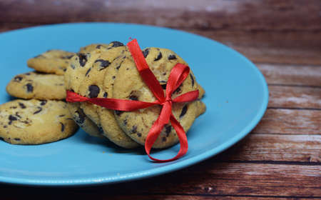 New Year's holiday biscuits with chocolate pieces and a red bow on a blue plate