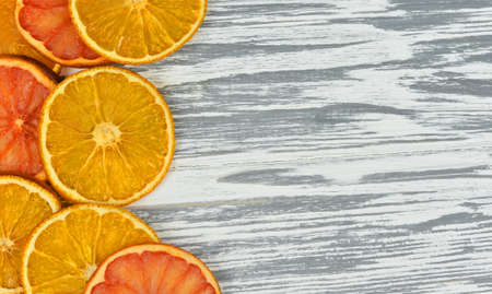 Pieces of orange and grapefruit on a white wooden texture on holidayの写真素材