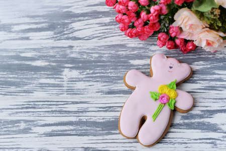 delicious gingerbread cookie teddy bear with flowers on a wooden background for the Spring Festival on March 8, Thanksgiving Day, Mother's Day, Easter and February 14の写真素材