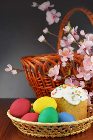 baking cake with icing glaze bread with eggs in a basket colored on a wooden background of flowers...
