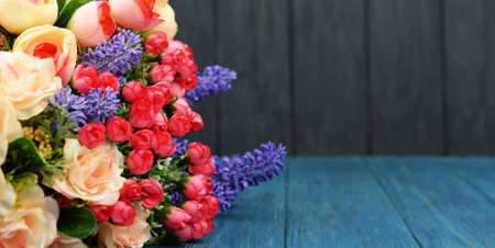 beautiful spring bouquet of flowers from roses and lavender on a wooden blue backgroundの写真素材
